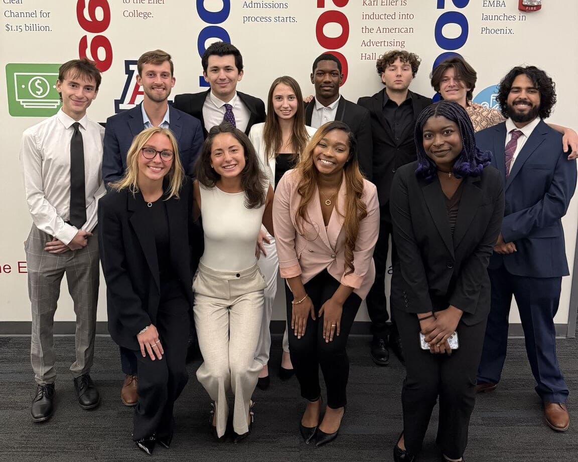 Quantitative Finance Club members gathered in front of the Eller College history wall.